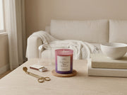 Apsaa Living Dark Rose and Mystic Sandalwood ombre candle styled in cozy luxury home setting with books and warm lighting