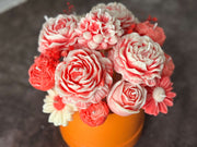 Bouquet of Red and White flowers in an orange vase.