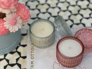 Two crystal jar candles, one with a dusty pink other with a clear crystal exterior
