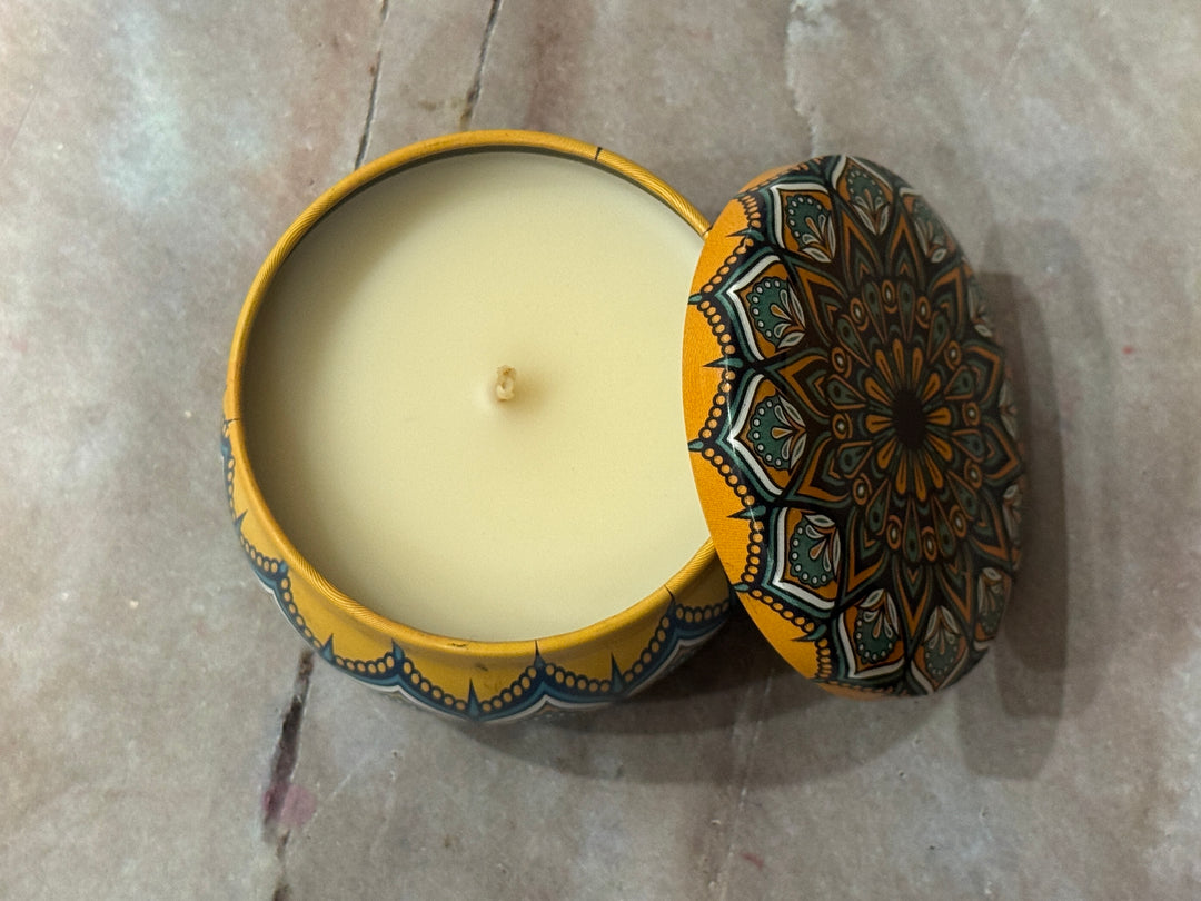Candle in a decorative tin with a madala patterned lid.
